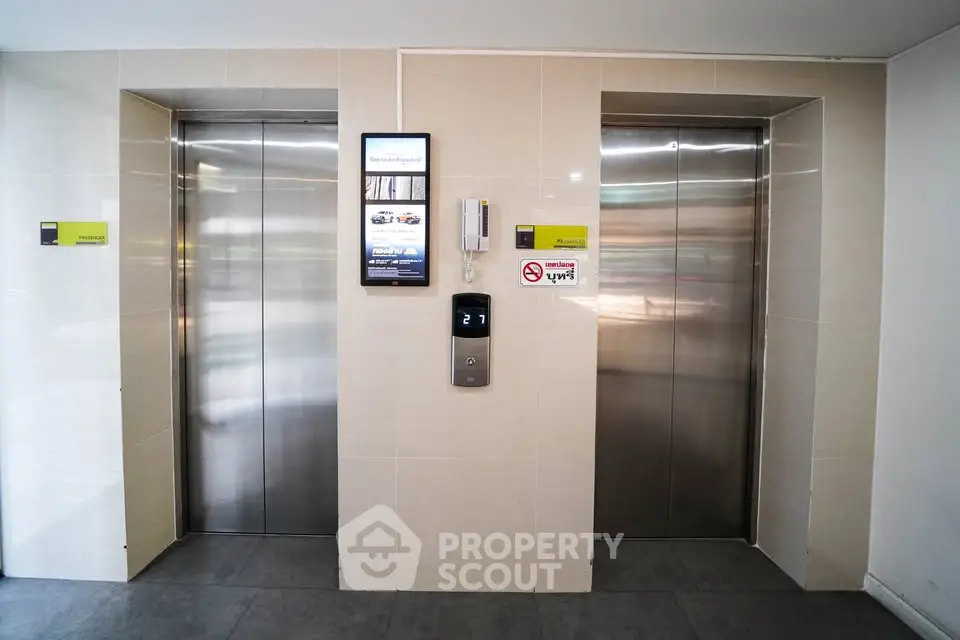 Modern building elevator lobby with sleek design and digital display