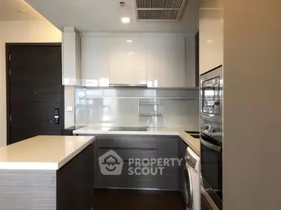 Modern kitchen with sleek cabinetry, built-in appliances, and a washing machine, perfect for urban living.