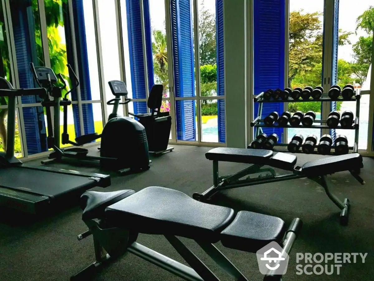 Luxurious gym with modern equipment and pool view in upscale property