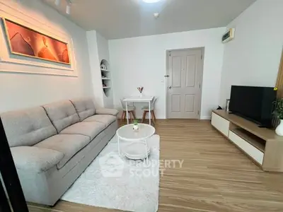 Modern living room with cozy sofa, stylish decor, and sleek TV setup in a bright apartment.