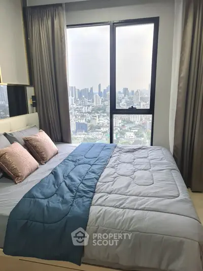 Luxurious bedroom with stunning city view from large window, featuring elegant decor and plush bedding.