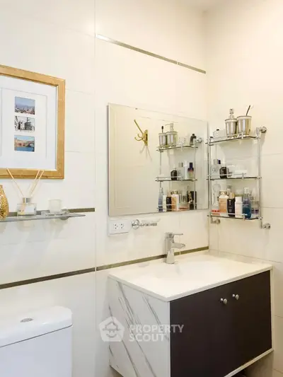 Modern bathroom with sleek vanity and wall-mounted shelves in elegant real estate property.