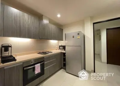 Modern kitchen with sleek cabinetry and stainless steel appliances in a stylish apartment.