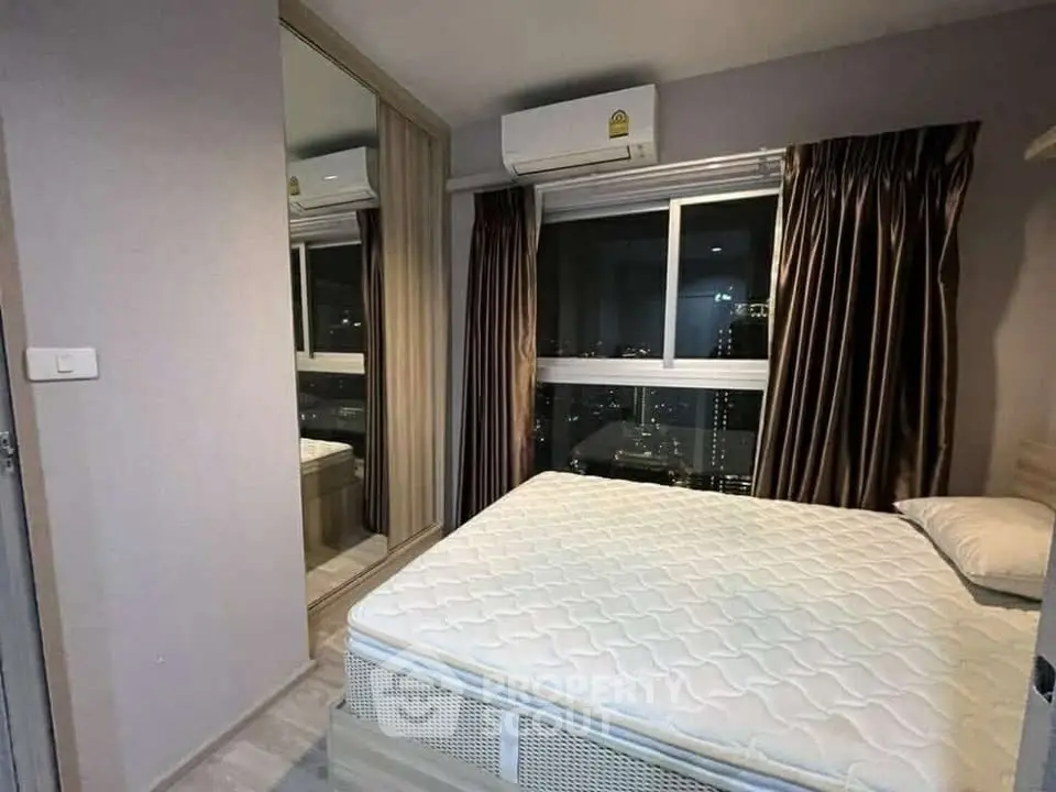 Modern bedroom with city view, featuring a comfortable bed and air conditioning.
