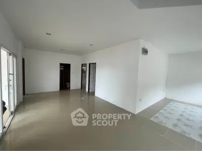 Spacious empty room with tiled flooring and white walls, ready for customization.