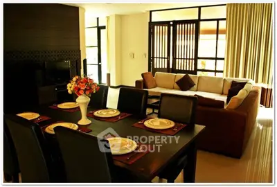 Elegant living room with dining area, featuring a cozy sofa and stylish dining table setup.