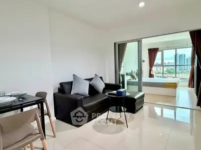 Modern open-plan living room with city view, featuring sleek furniture and large windows.