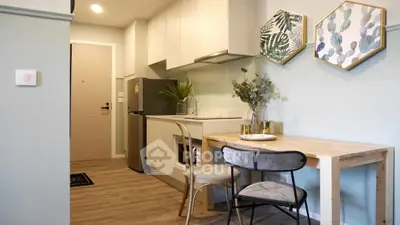 Charming compact kitchen with dining area, featuring modern decor and sleek appliances.