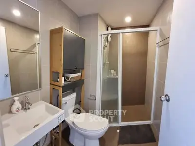 Modern bathroom with shower and sleek fixtures in contemporary apartment.