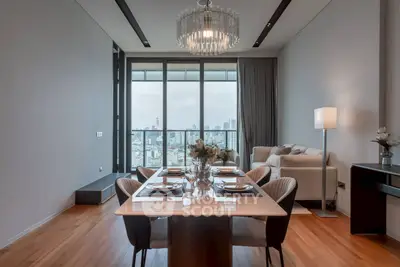 Luxurious dining area with city view, elegant chandelier, and modern decor.