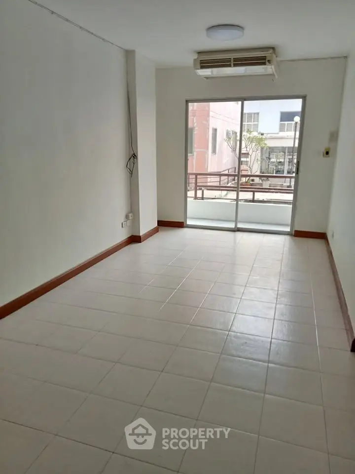 Spacious unfurnished room with large window and balcony access