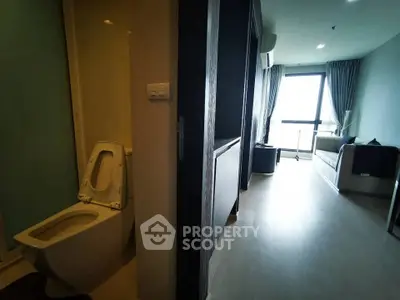 Modern apartment interior with open living space and bathroom, featuring sleek design and natural light.