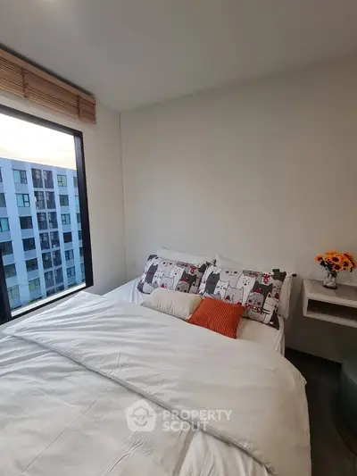 Cozy bedroom with large window and modern decor in urban apartment