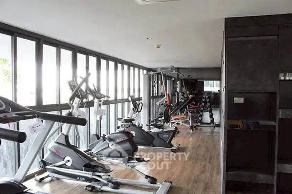 Modern gym with state-of-the-art fitness equipment and large windows for natural light.