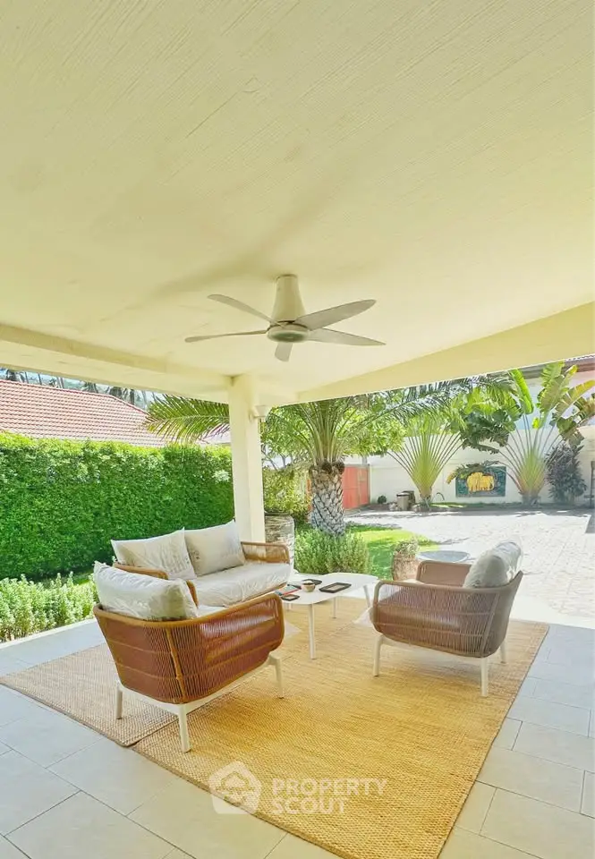 Charming outdoor patio with cozy seating and lush garden view, perfect for relaxation and entertaining.
