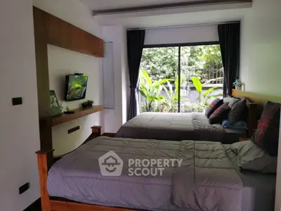 Cozy bedroom with twin beds and garden view, perfect for relaxation and comfort.