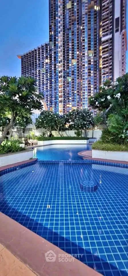 Luxurious high-rise building with stunning pool and lush greenery, perfect for urban living.