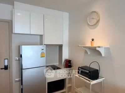 Modern kitchen with sleek appliances and minimalist design, featuring a compact fridge and stylish shelving.