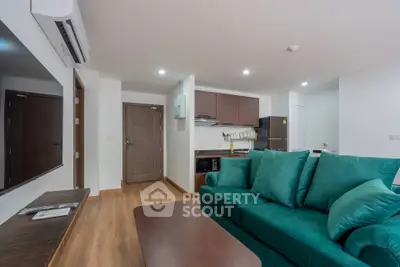 Modern living room with green sofa and open kitchen layout