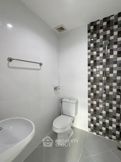 Modern bathroom with stylish tile accent wall and sleek fixtures.