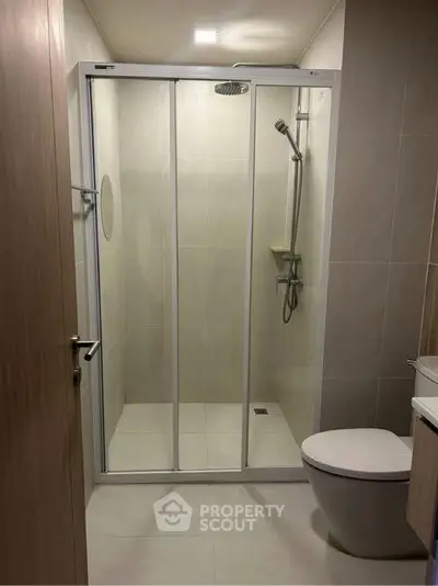 Modern bathroom with glass shower enclosure and sleek fixtures.