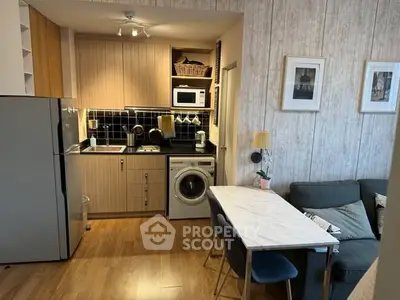 Chic open-layout kitchen with modern appliances and cozy dining area in stylish apartment.