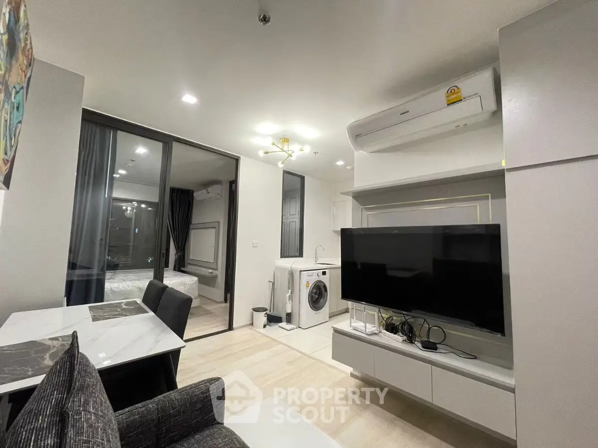 Modern living room with sleek design, featuring a washing machine and air conditioning unit.