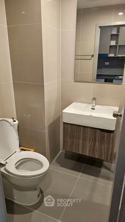 Modern bathroom with sleek fixtures and neutral tiles in a contemporary apartment.