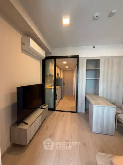 Modern living room with sleek furniture and open kitchen layout in a stylish apartment.
