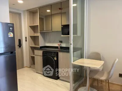 Modern compact kitchen with integrated washing machine and cozy dining area