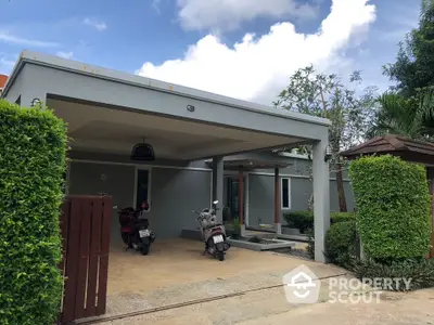 Modern single-story home with carport and lush greenery