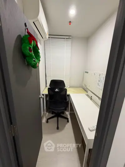Compact study room with modern desk and chair, featuring a festive wreath on the door.