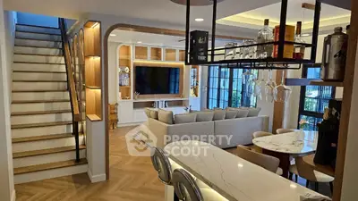 Modern open-concept living room with stylish kitchen and elegant staircase