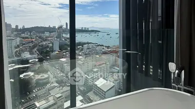 Luxurious bathroom with stunning city and ocean view from high-rise building.