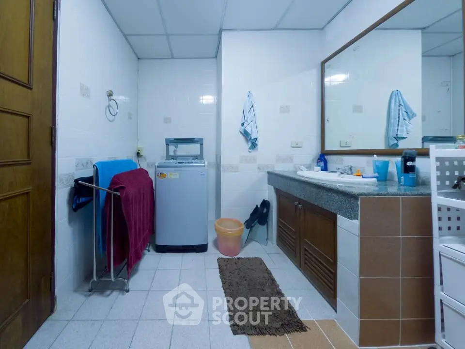 Spacious bathroom with washing machine and large mirror