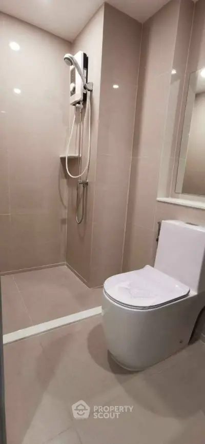 Modern bathroom with sleek fixtures and walk-in shower in a contemporary apartment.