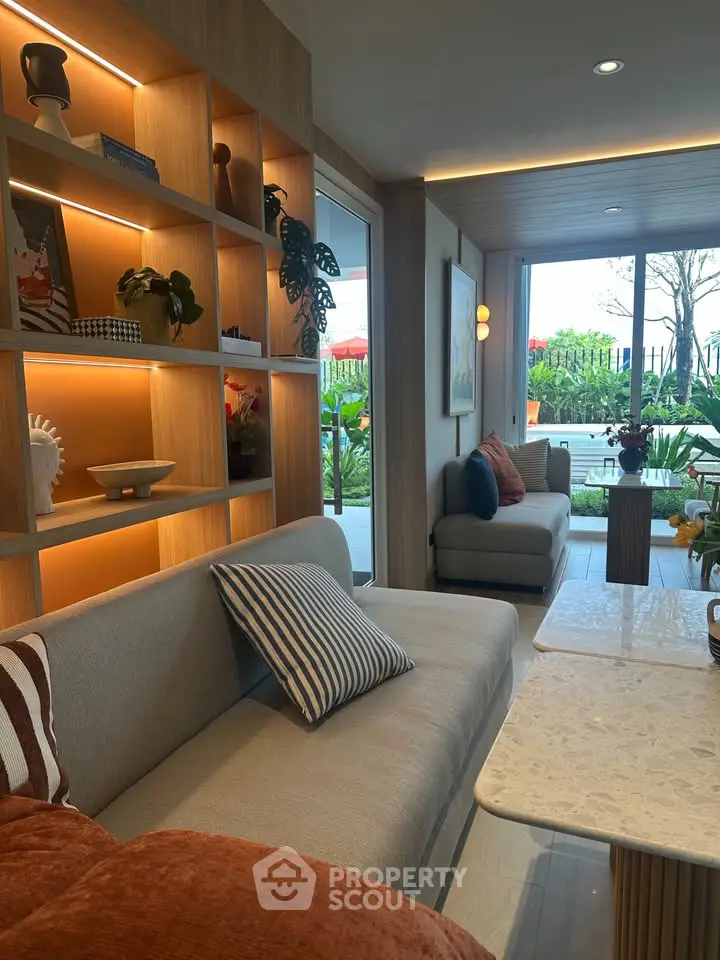 Stylish living room with modern decor and garden view, featuring cozy seating and elegant shelving.