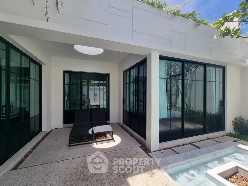 Modern villa exterior with sleek glass doors and private pool area, perfect for luxury living.