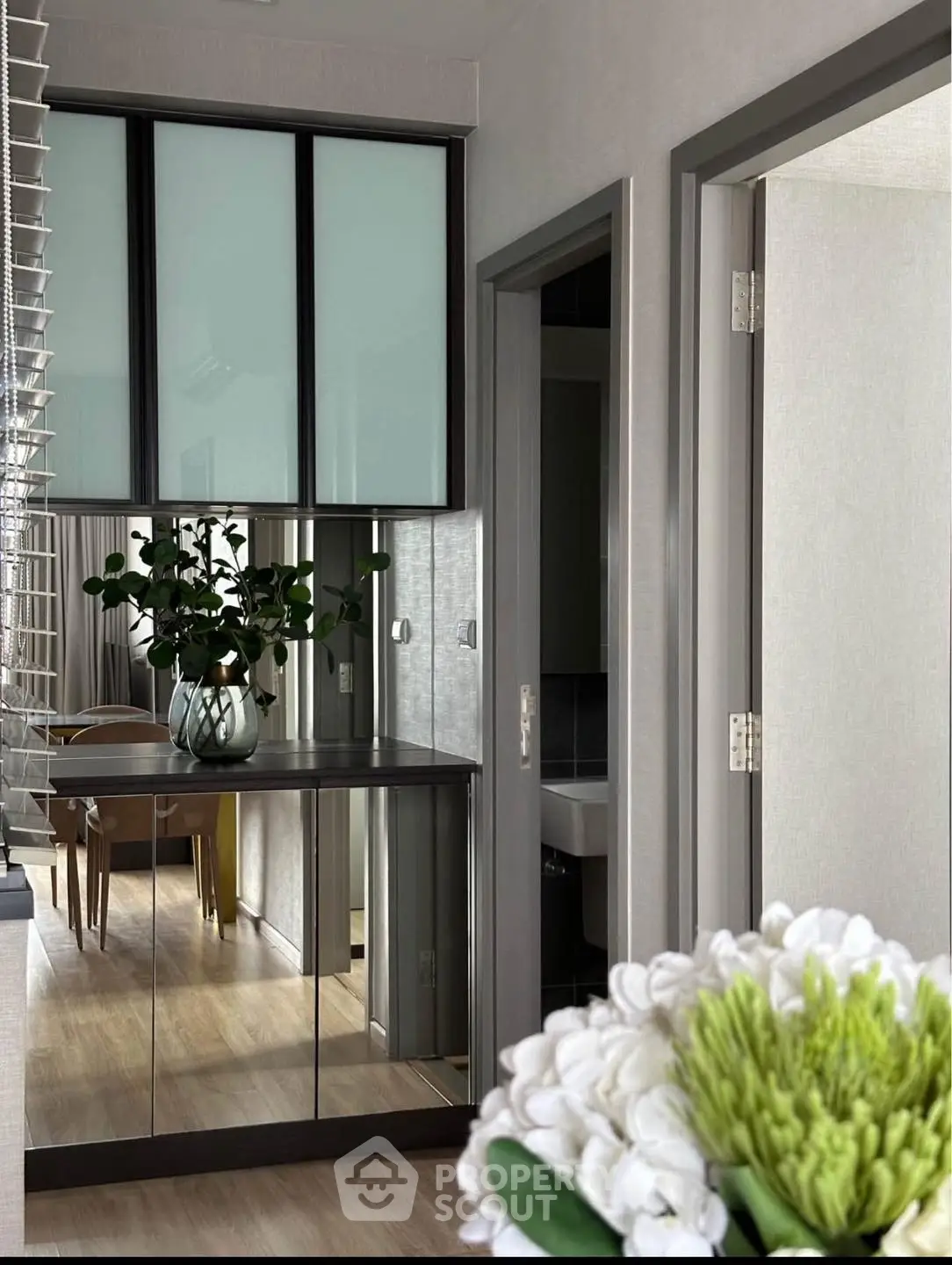 Modern hallway with mirrored cabinet and dining area view