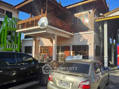 Charming two-story house with wooden balcony and ample parking space in a vibrant neighborhood.