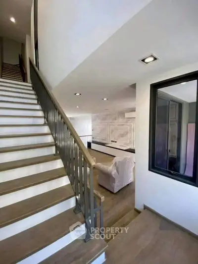 Modern interior with stylish staircase and cozy living area, perfect for contemporary living.