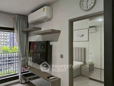 Modern living room with wall-mounted TV and balcony view in stylish apartment.