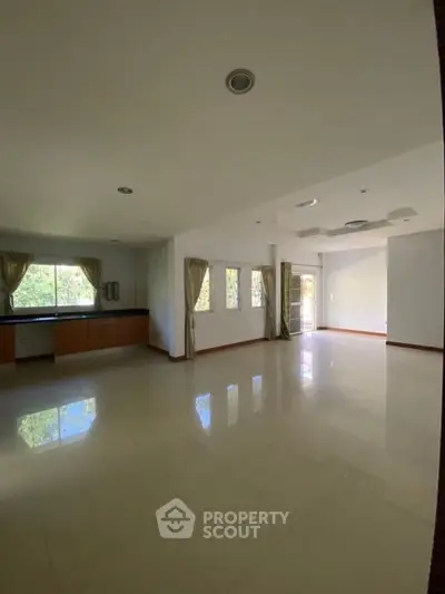 Spacious empty living room with large windows and natural light