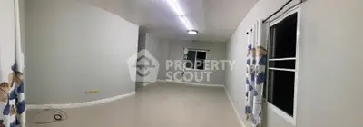 Spacious empty living room with modern lighting and large windows.