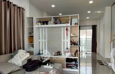 Spacious living room with modern decor and ample natural light, featuring a stylish partition and cozy seating area.