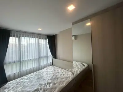 Spacious bedroom with large windows and modern furnishings in a stylish apartment.