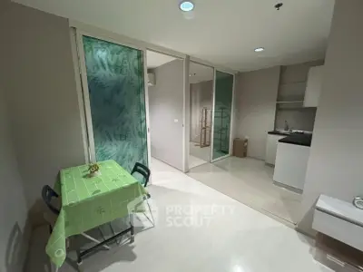 Modern apartment interior with compact kitchen and dining area, featuring sleek design and efficient use of space.
