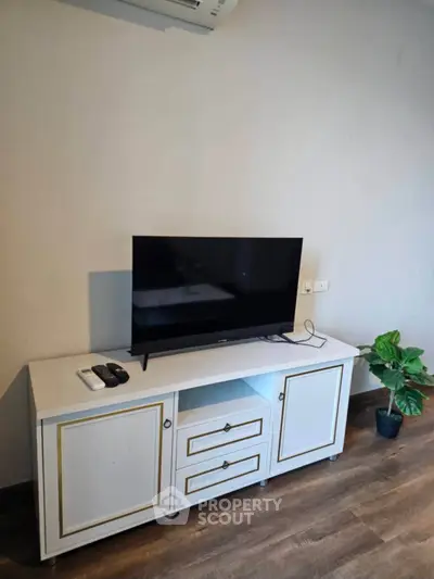 Modern living room with sleek TV stand and flat-screen TV, perfect for cozy entertainment.