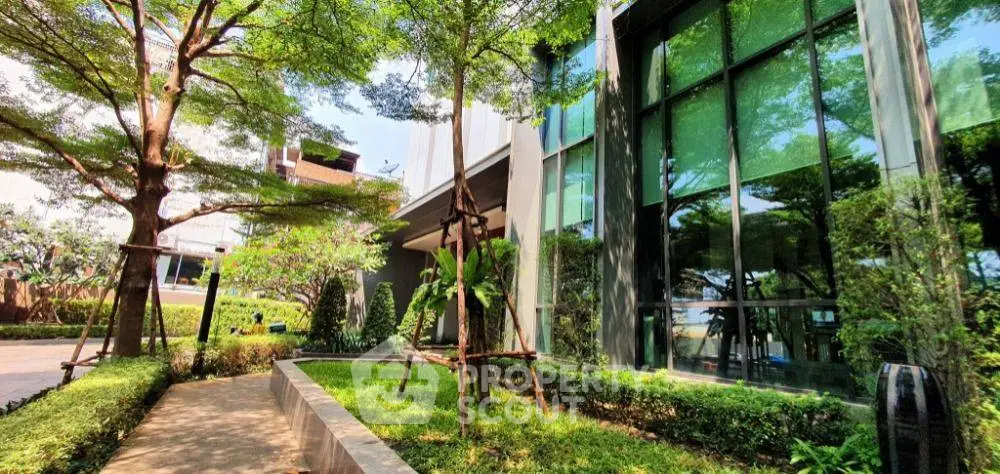 Modern building exterior with lush garden and large windows