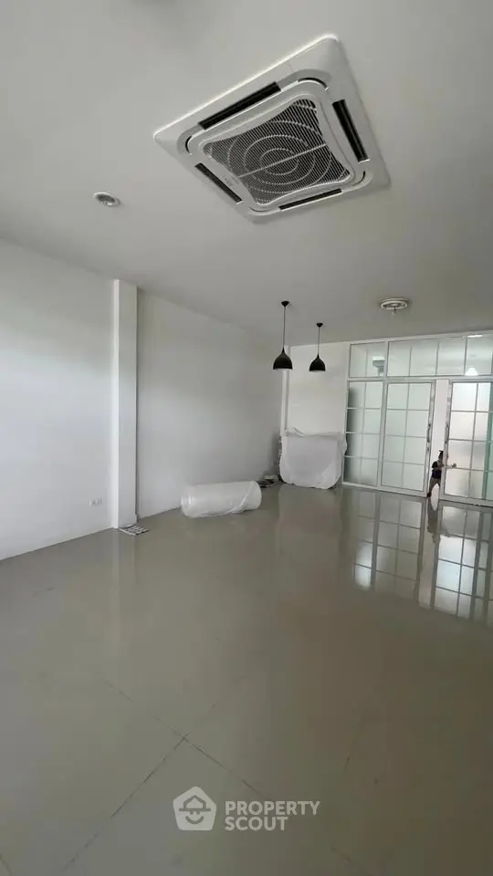 Spacious unfurnished room with modern ceiling air conditioning and sleek lighting fixtures.